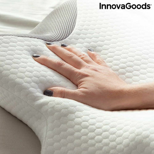 A hand presses into a white, contoured InnovaGoods foam pillow with a hexagonal textured fabric cover.