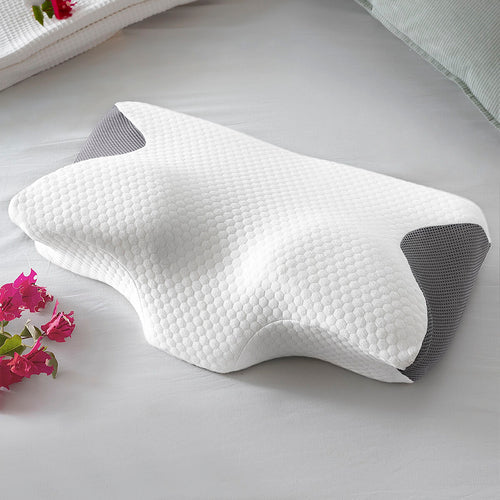 Contoured white and grey fabric neck pillow with a honeycomb texture, shown on a grey bedsheet.