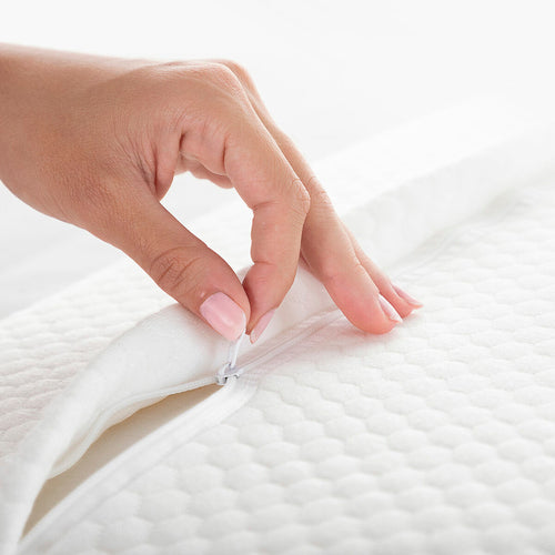 A hand opening the white zipper on a textured white fabric pillow cover for the InnovaGoods Conforti neck pillow.